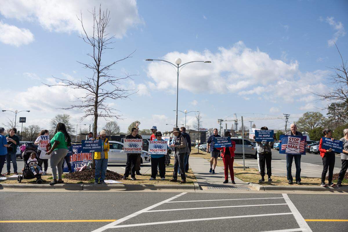 Protesters gather on the sidewalk during the “US Mail Not For Sale” rally outside of the Postal Service’s Park Road office in Charlotte on Thursday.