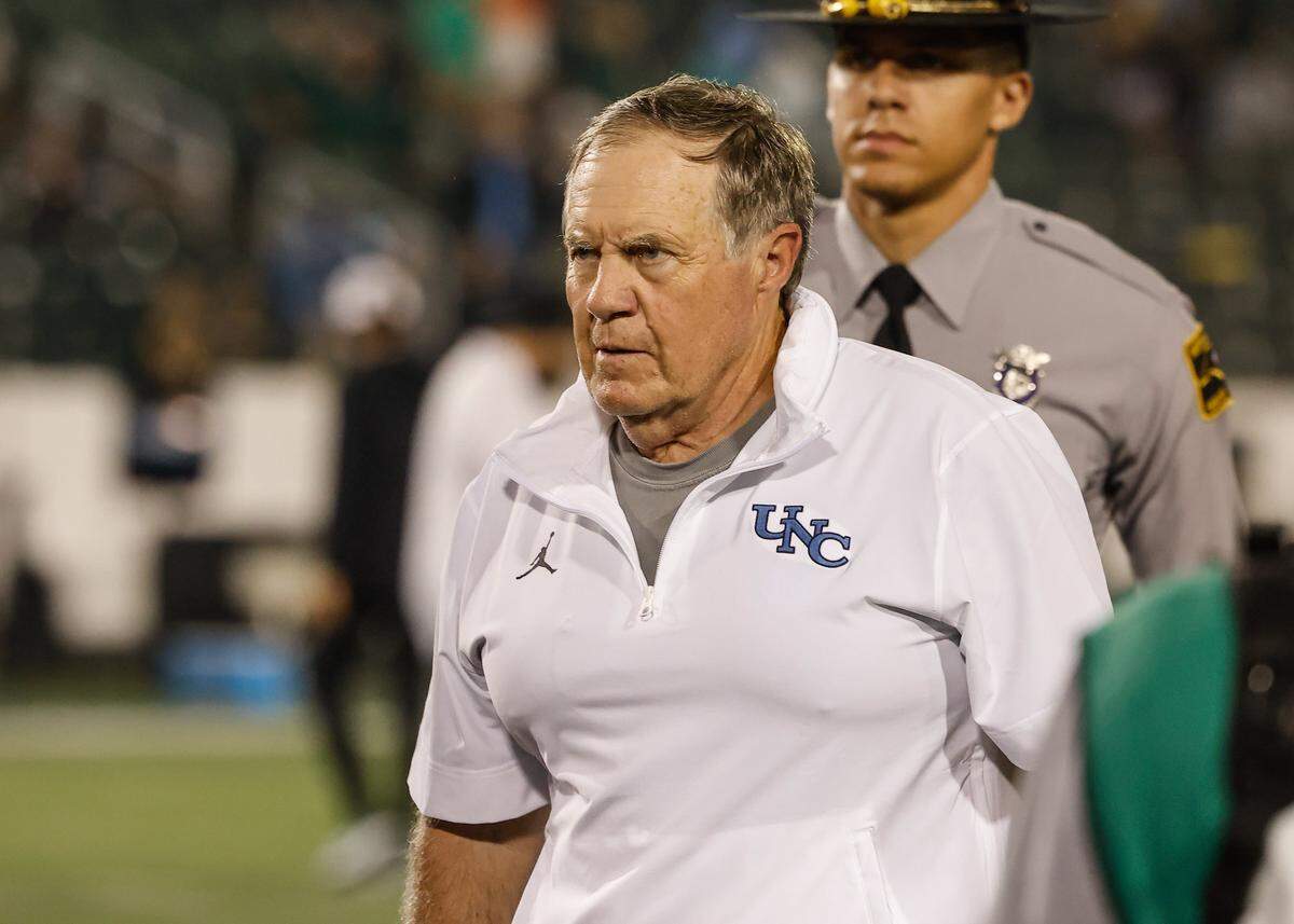 Chapel Hill Head Coach Bill Belichick is escorted off the field after a win over Charlotte, 20-3, giving the coach his first college win at Jerry Richardson Stadium on Saturday, September 6, 2025.