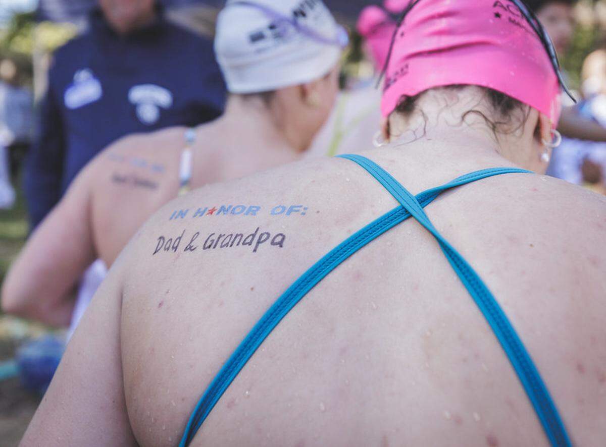 Swim Across America partipants write who they are swimming for before embarking on their swim on Lake Wylie.