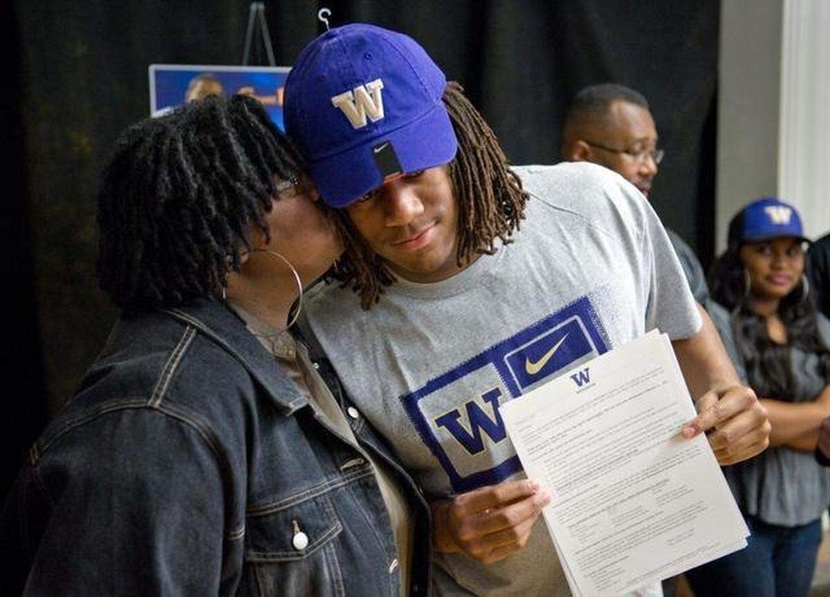 Panthers linebacker Shaq Thompson gets a kiss from his mother Patty Thompson after he signed his letter of intent to play football at the University of Washington in 2012.