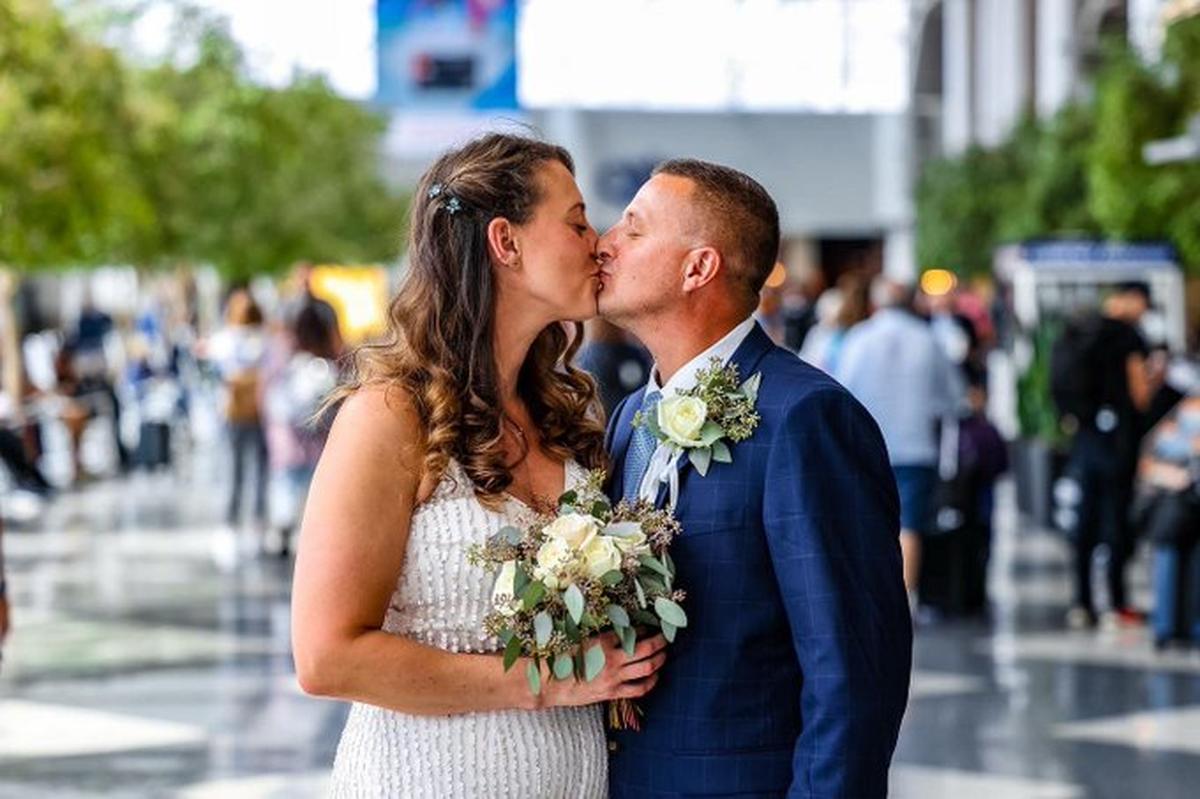 Elizabeth Evers and Adam Johnson kiss after saying “I do” in the Atrium of Charlotte Douglas International Airport on Friday, Sept. 9, 2022.