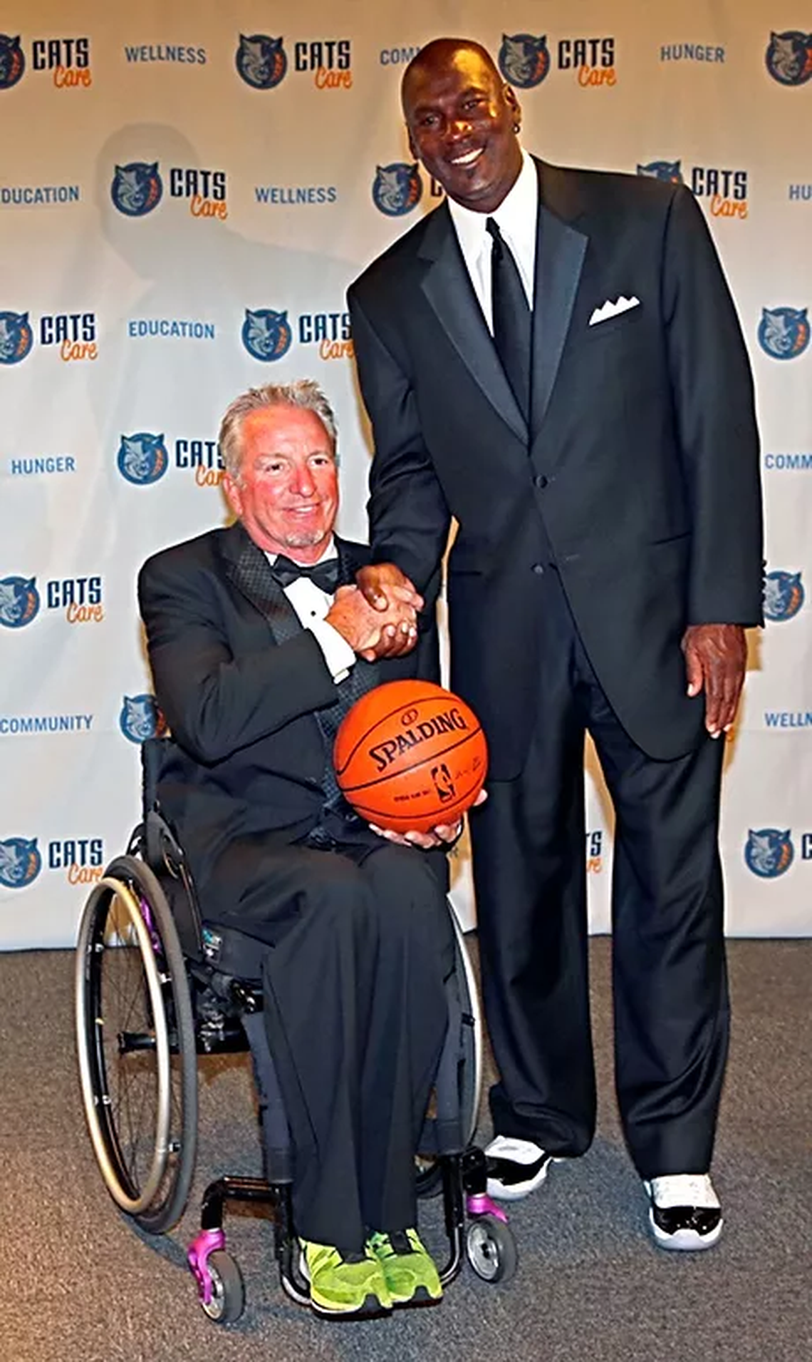 Paralympic gold medalist David Kiley shakes hands with Charlotte Hornets owner Michael Jordan.