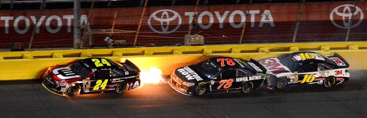 NASCAR Sprint Cup Series driver Jeff Gordon's (24) car begins to kick up flames after an accident with Martin Truex Jr. (78) and Greg Biffle (16) during the Sprint All Star Race at Charlotte Motor Speedway in Concord, NC on Saturday, May 17, 2014. 