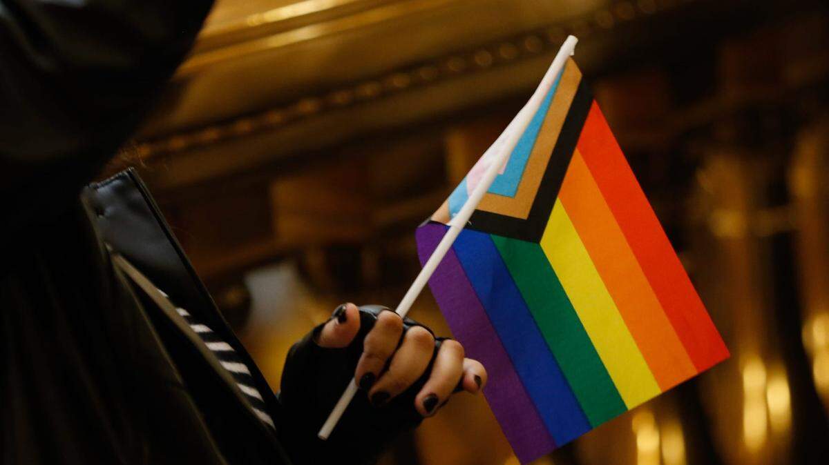 A person holds an LGBTQ+ flag during the Equality Kansas Advocacy Day rally at the Statehouse Wednesday, Jan. 31, 2024.