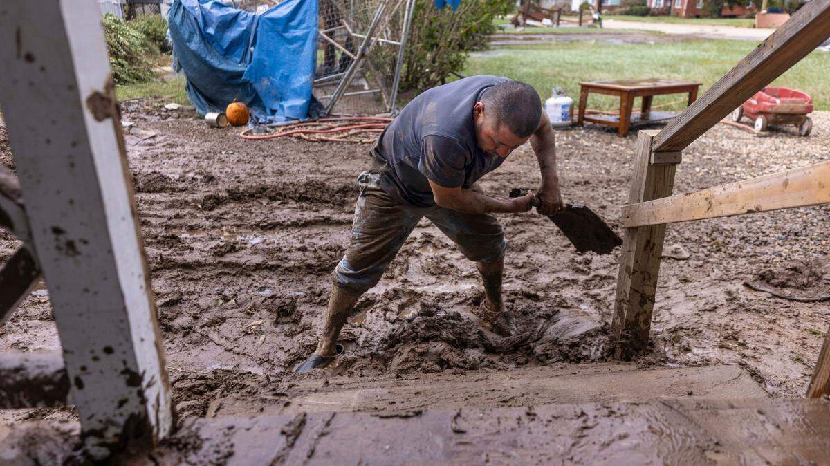 Tomas Quiroz shovels mud from his porch steps in Clyde on Saturday, Sept. 28, 2024, after massive flooding damaged dozens of homes and businesses.