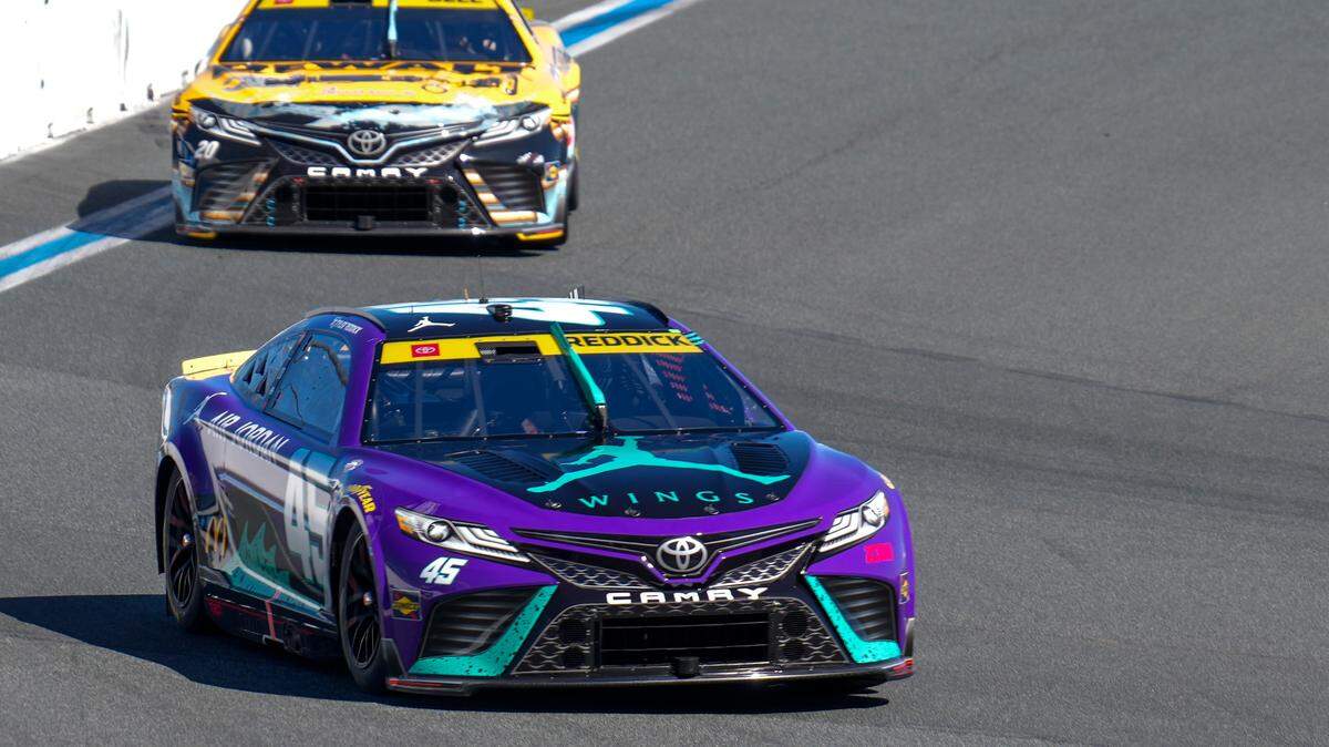 Oct 8, 2023; Concord, North Carolina, USA; NASCAR Cup Series driver Tyler Reddick (45) leads driver Christopher Bell (20) out of turn eight during the Bank of America Roval 400 at Charlotte Motor Speedway Road Course. Mandatory Credit: Jim Dedmon-USA TODAY Sports