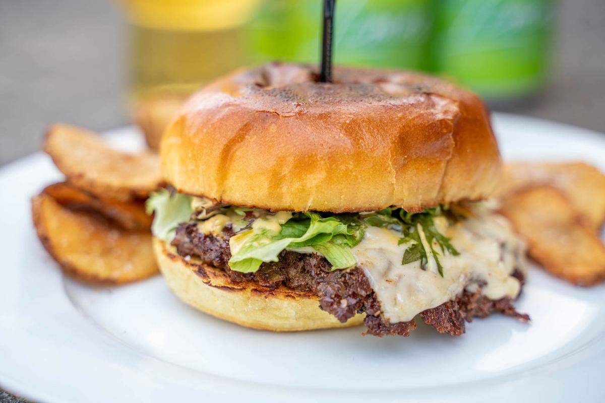 At Izzy’s at Triple C Brewing, the Izzy Burger is made with Mullis Family Farm smashed beef, white American cheese, Izzy sauce (mustard, mayo, ketchup and relish) and shredded lettuce on a brioche bun — and it is stabbed with a knife.