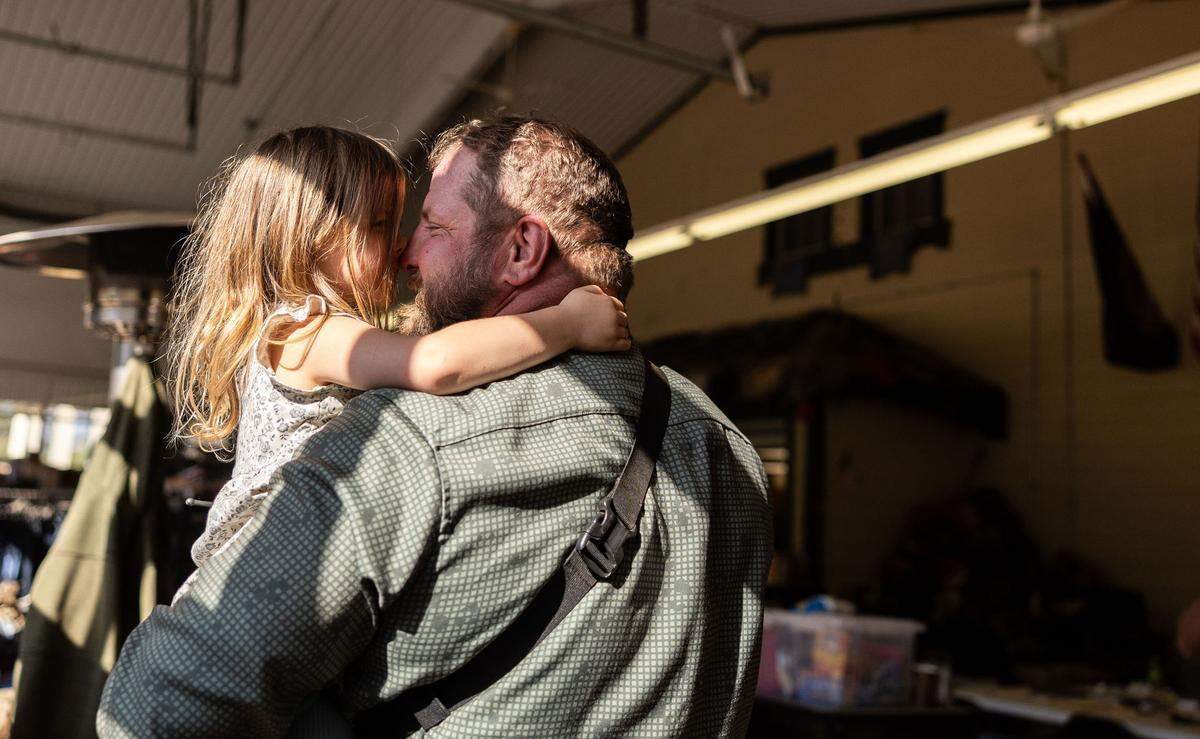 Adam Smith holds his daughter, Tove, 3, at Savage Operations Center inside of a Harley Davidson store in Swannanoa, N.C. on Tuesday, October 8, 2024.