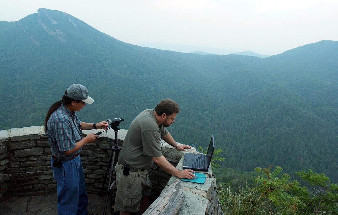 In this 2005 file photo, Appalachian State astronomy professor Dan Caton, left, adjust a web cam as Lee Hawkins reviews his computer at Wiseman’s View Overlook, near Linville. The pair were leading a group investigating the legend of the Brown Mountain Lights which had reportedly been seen in the area.