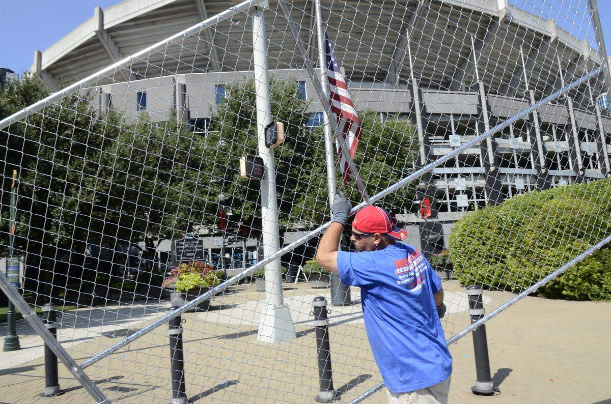 A worker sets up barricade fencing surrounding Bank of America Stadium in preparation for the 2012 Democratic National Convention.
