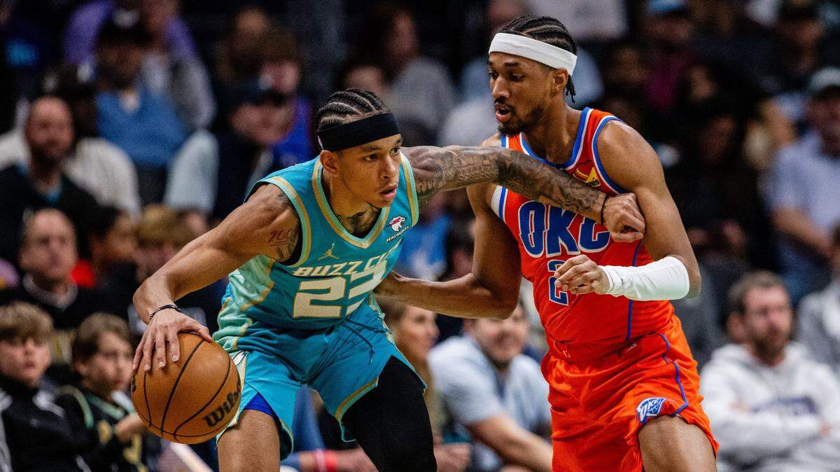 Charlotte Hornets guard Tre Mann (23) drives around Oklahoma City Thunder guard Aaron Wiggins during the first quarter at Spectrum Center.