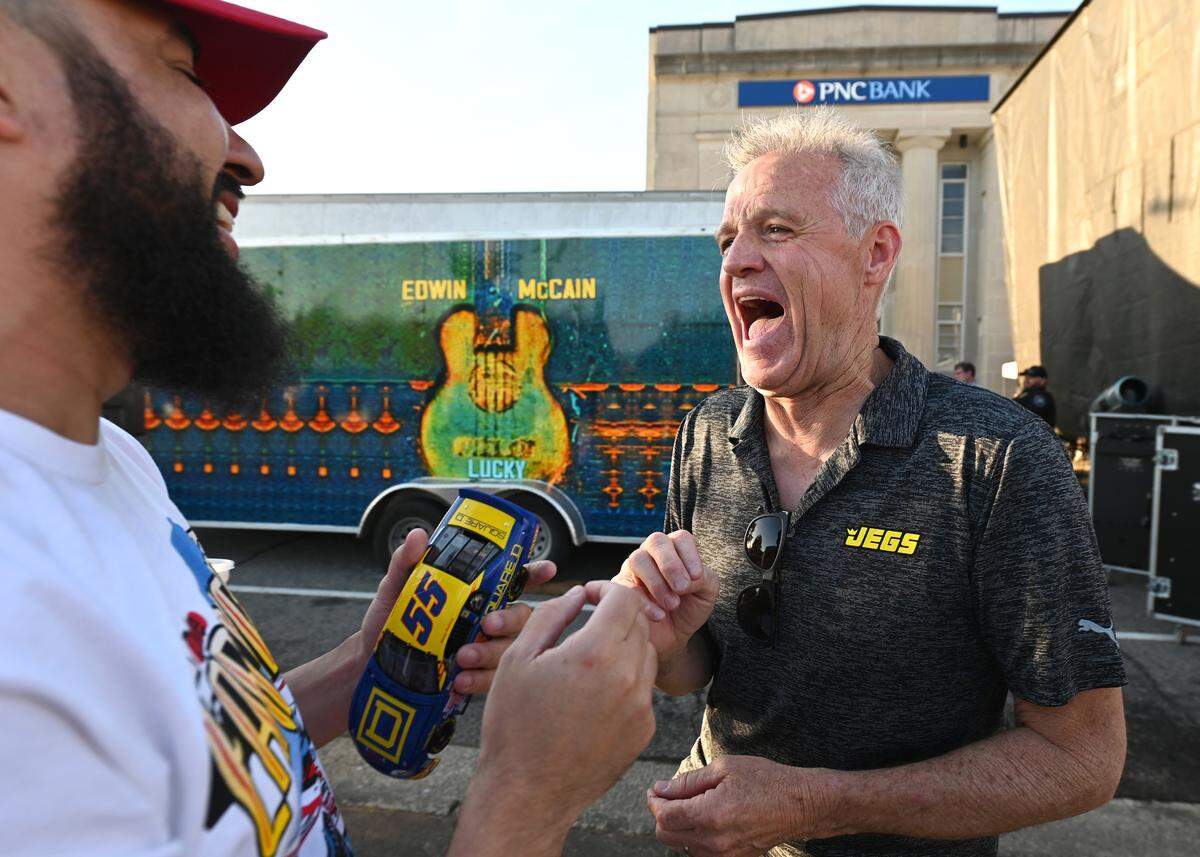 Former NASCAR driver Kenny Wallace, left, enjoys time with a fan during Thunder Fest in downtown Rockingham, NC on Thursday, April 17, 2025. Fans are celebrating the return of the NASCAR Craftsman Truck Series and XFINITY Series to Rockingham Speedway this weekend.