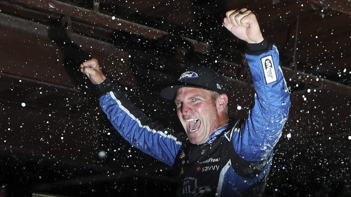 Clint Bowyer is doused after winning a shortened NASCAR Cup Series race on Sunday in Brooklyn, Mich.
