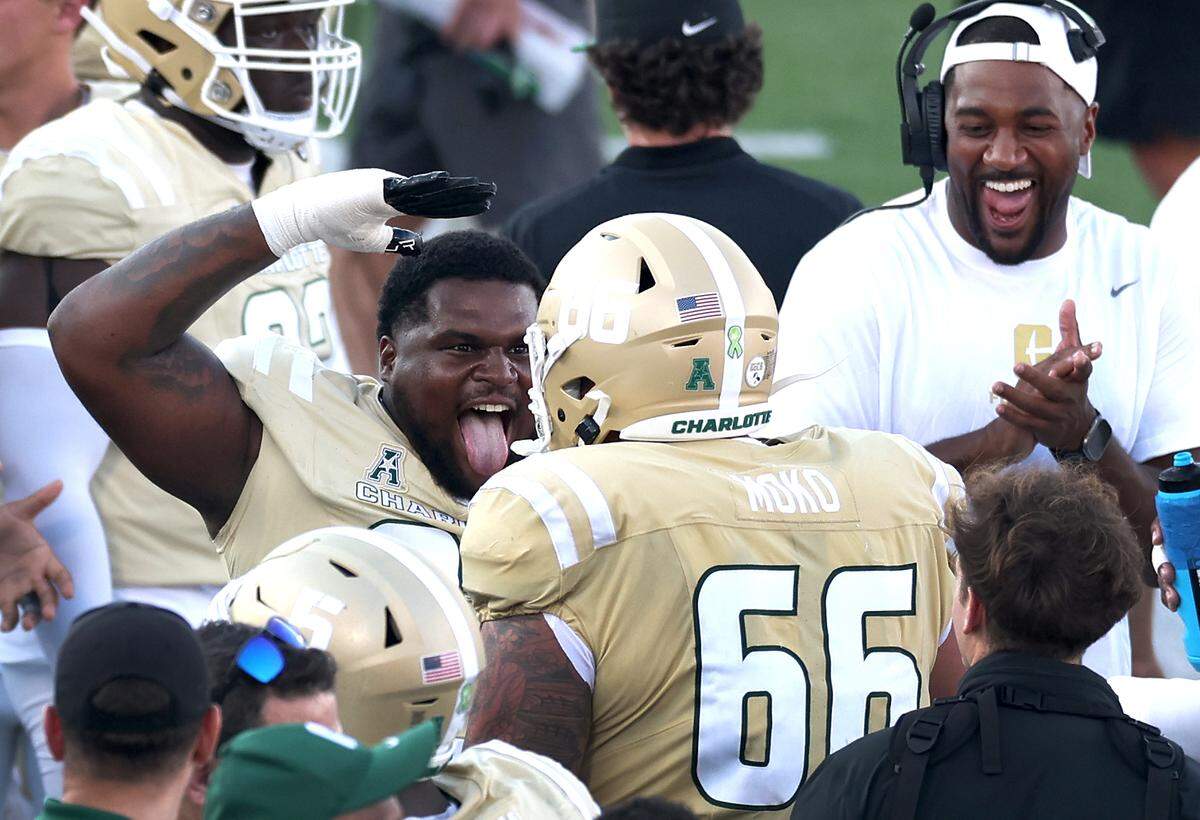 Charlotte 49ers defensive lineman Jamar Holley, center, celebrates the team’s play during fourth-quarter action against the East Carolina Pirates on Saturday.