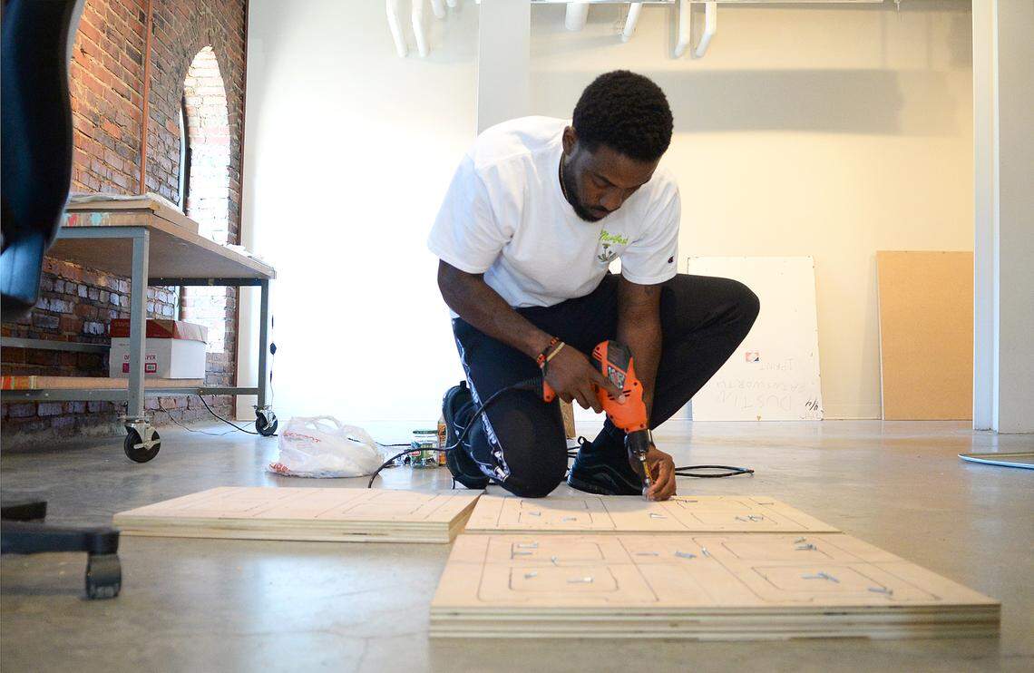 Sherrill Roland’s work is featured in the “...and justice for all” exhibition at the Gantt Center for African-American Arts + Culture. He is pictured here making faux cinder blocks out of plywood at the McColl Center. His art is inspired by his wrongful conviction and incarceration. He spent nearly a year in jail.