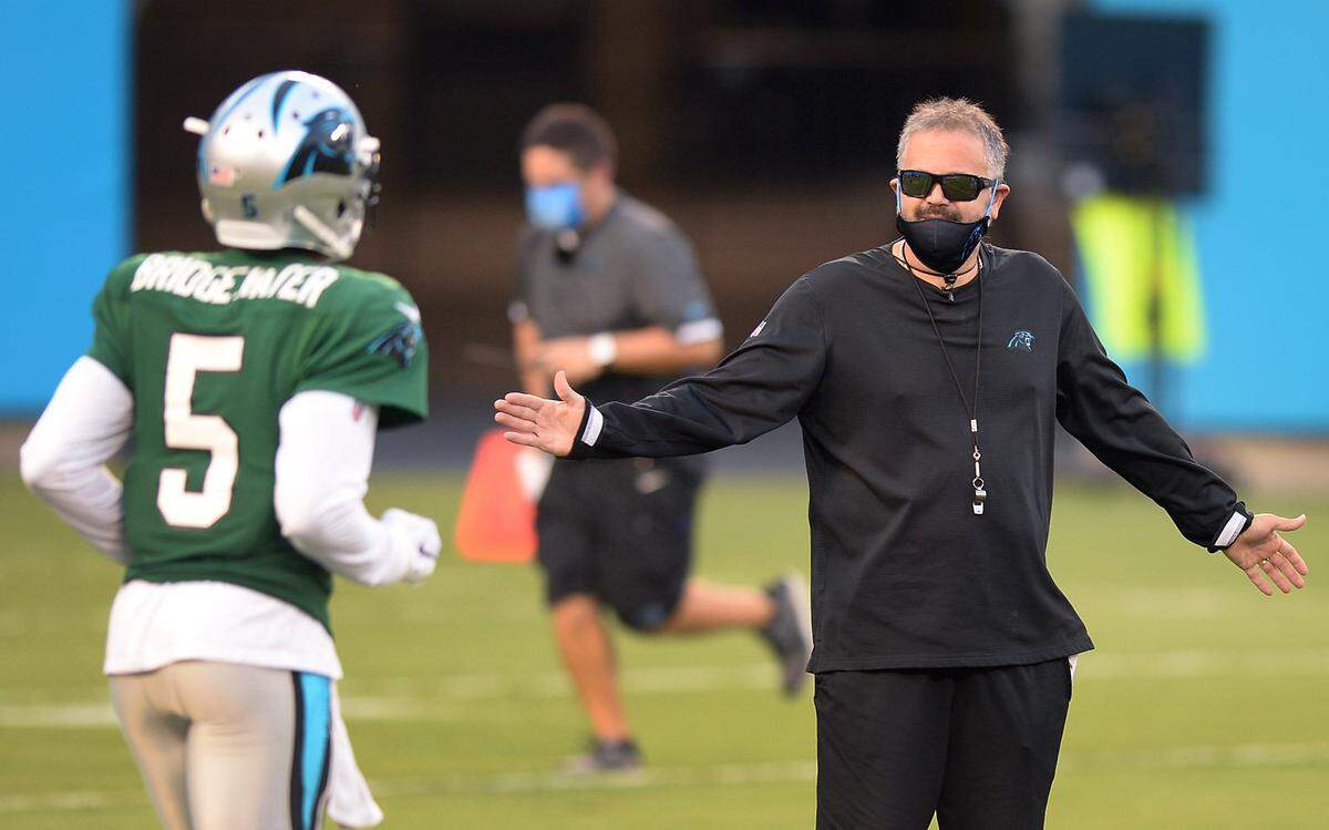 Carolina Panthers head coach Matt Rhule, right, welcomes quarterback Teddy Bridgewater to the field during a practice in August. Both men will make their debut as Panthers Sept. 13th, when the team hosts the Las Vegas Raiders
