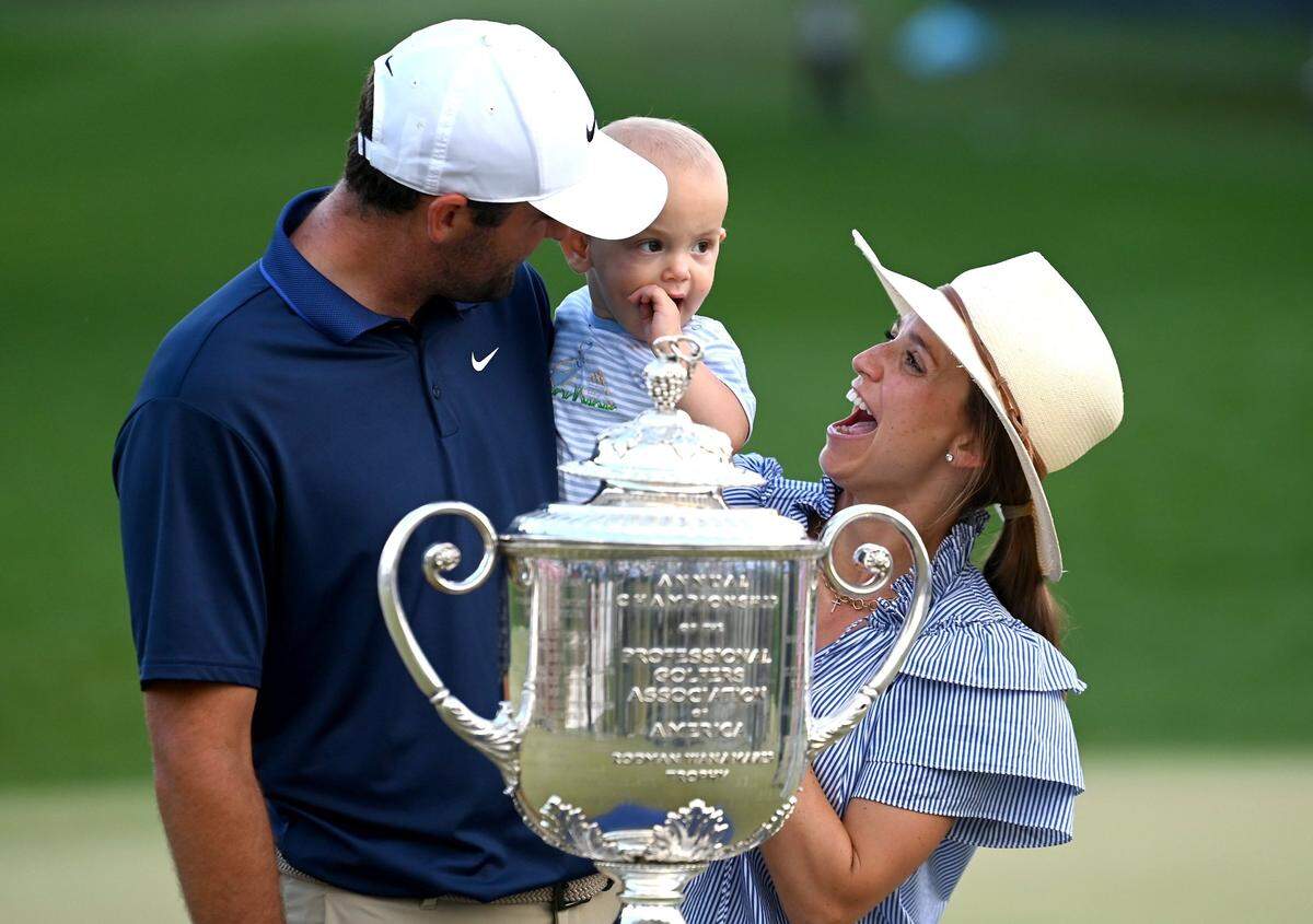 Scottie Scheffler, left, celebrates winning the PGA Championship with son, Bennett, center, and wife, Meredith, right, at Quail Hollow Club in Charlotte on Sunday, May 18, 2025. Scheffler shot -11 for the tournament.