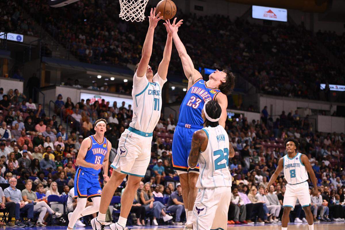 Charlotte Hornets center Ryan Kalkbrenner (11) and Oklahoma City Thunder Brooks Barnhizer (23) fight for a rebound in the first quarter at North Charleston Coliseum. 