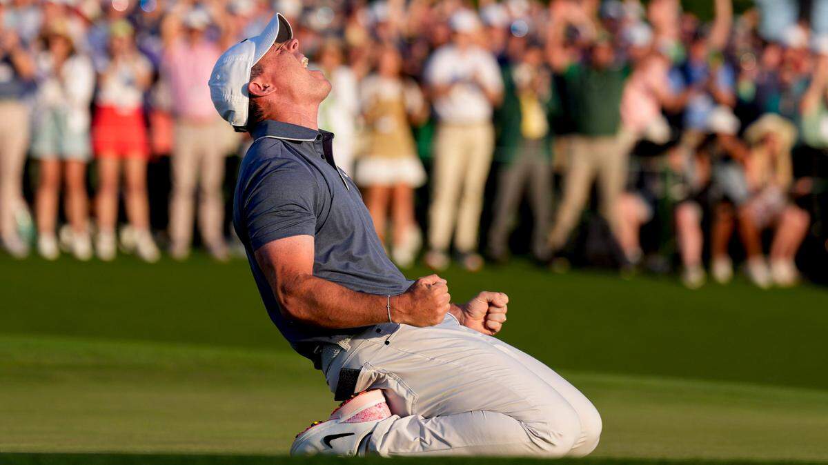 Rory McIlroy falls to his knees in celebration after winning a playoff on the No. 18 green during the final round of the Masters Tournament at Augusta National Golf Club.