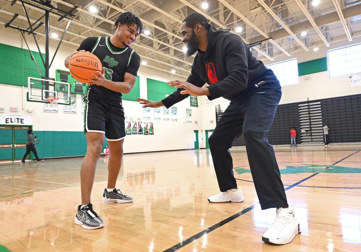 AJ Jamison, left, the son of former UNC great and NBA star Antawn Jamison, right, playfully square up at Myers Park High School in Charlotte, NC on Wednesday, January 15, 2025. AJ Jamison is enjoying a really good senior season at Myers Park which is trying to win the league title.
