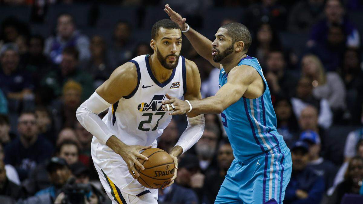 Utah Jazz center Rudy Gobert, left, looks to pass against Charlotte Hornets guard Nicolas Batum in the second half of an NBA basketball game in Charlotte, N.C., Saturday, Dec. 21, 2019. Utah won 114-107. (AP Photo/Nell Redmond)