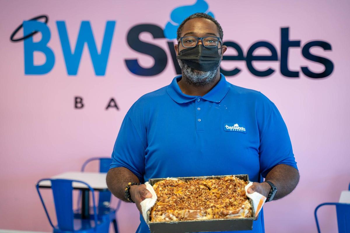 Frankie White, owner and operator of BW Sweets Bakery, holds a pan of his best-selling caramel pecan rolls.
