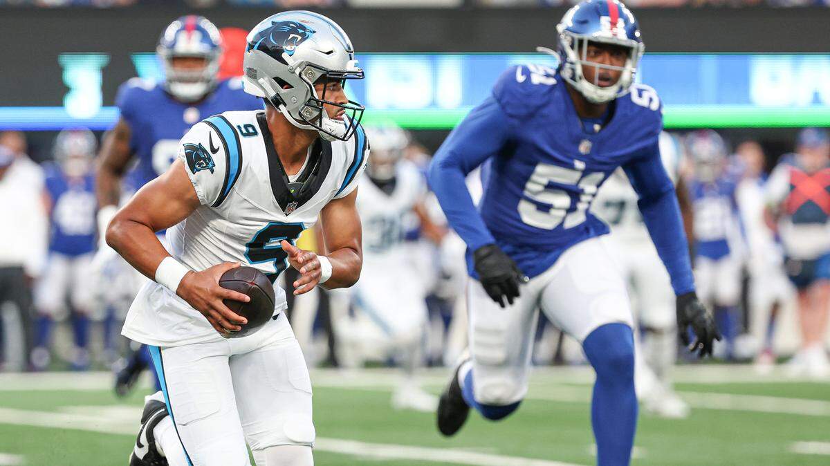 Aug 18, 2023; East Rutherford, New Jersey, USA; Carolina Panthers quarterback Bryce Young (9) scrambles in front of New York Giants linebacker Azeez Ojulari (51) during the first quarter at MetLife Stadium.