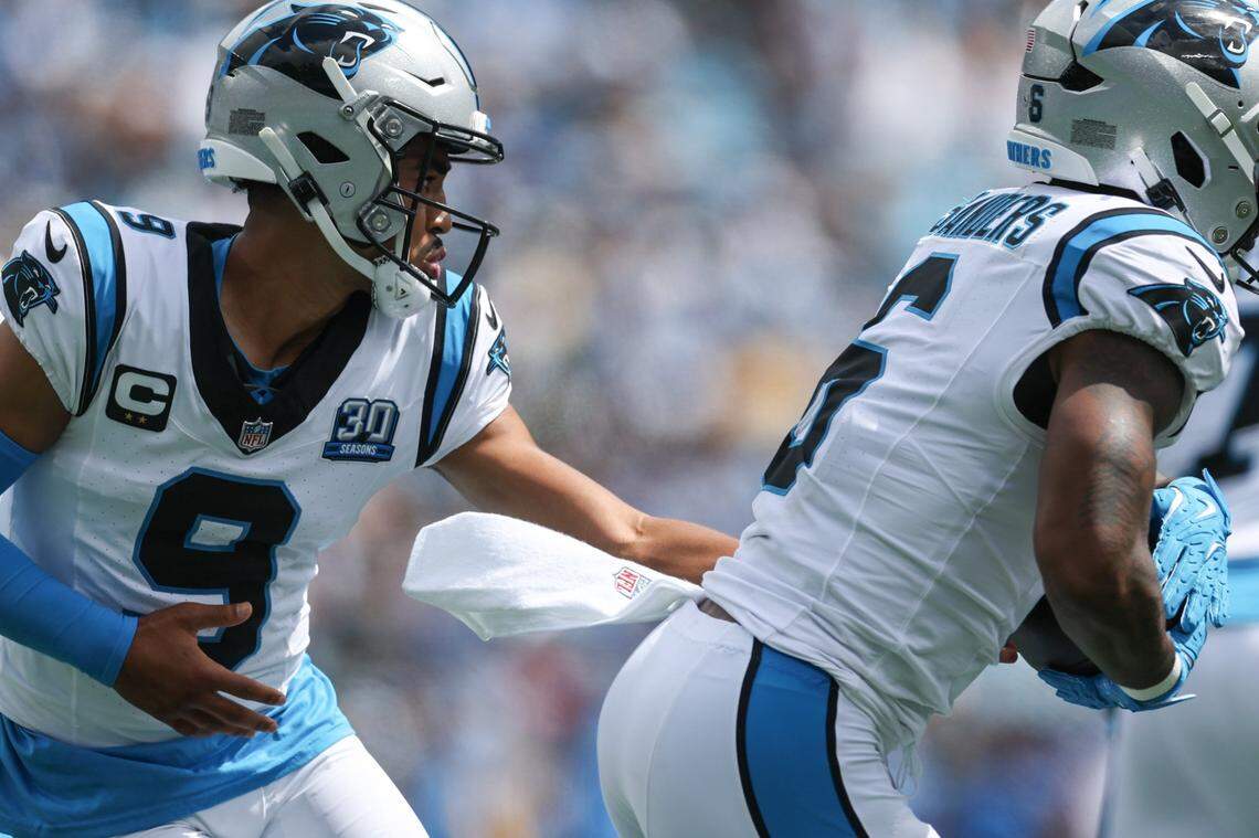 Panthers quarterback Bryce Young hands the ball off to runningback Miles Sanders during the game against the Chargers at Bank of America Stadium in Charlotte, NC on Sunday, September 15, 2024.