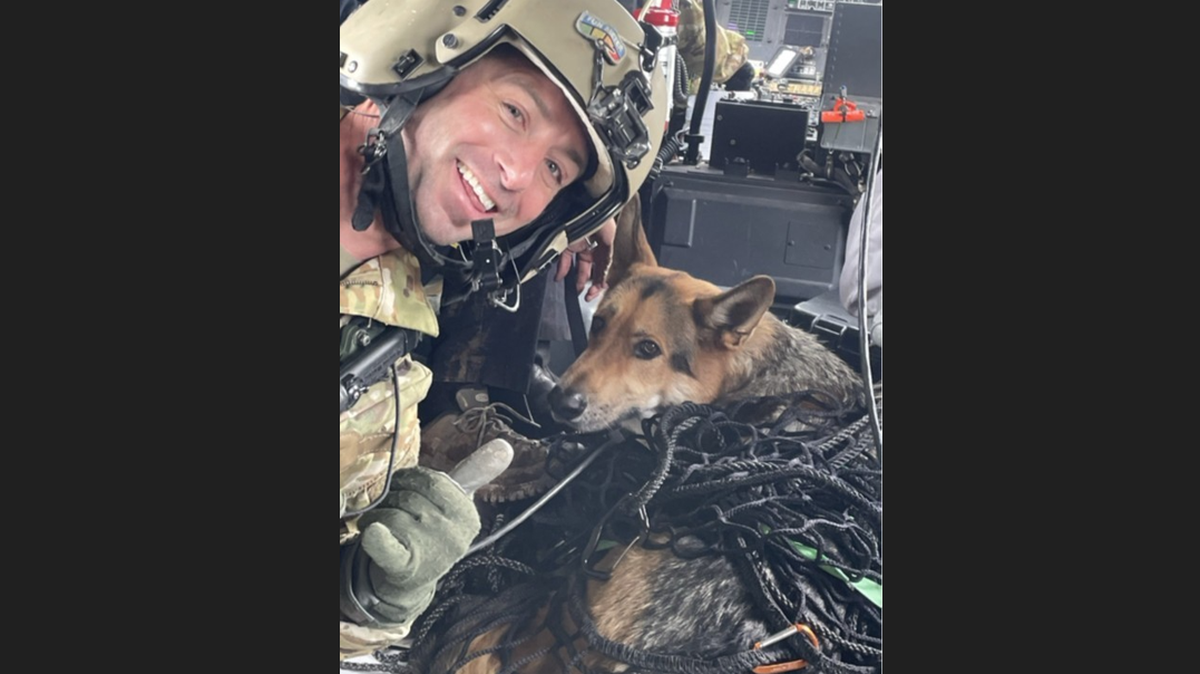 Sgt. 1st Class John Sharbel, a flight paramedic with the Tennessee Army National Guard’s 1-230th Assault Helicopter Battalion, with Jack, a German shepherd, just after the dog was hoisted into a Blackhawk helicopter during a rescue at Cherokee National Forest.