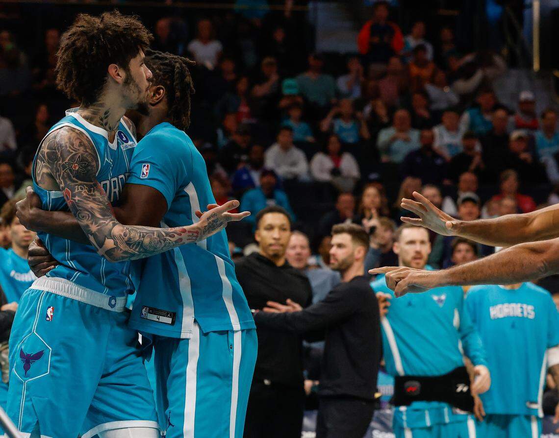 Hornets guard LaMelo Ball is held back by a teammate as he reacts after being pushed off the court  by Wizards’ guard Kyshawn George during Tuesday’s game at Spectrum Center.
