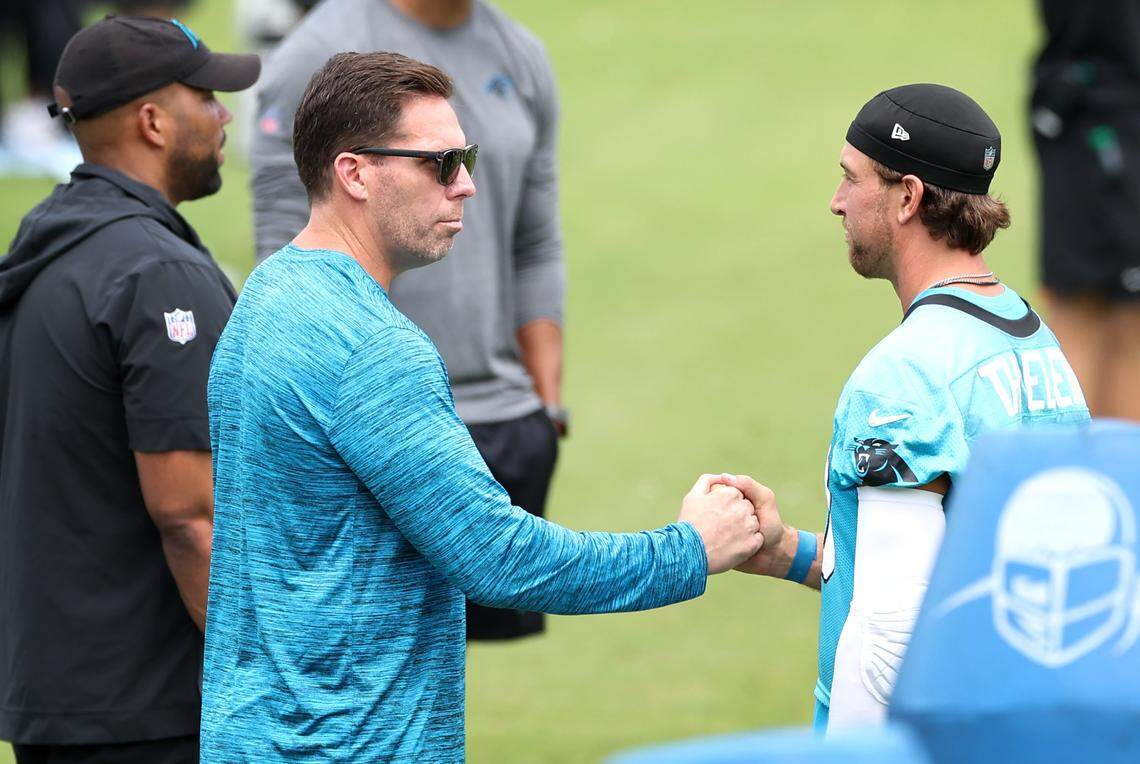 Carolina Panthers general manager Dan Morgan, left, shakes hands with wide receiver Adam Thielen, right, during the team’s OTA practice on Tuesday, June 4, 2024.