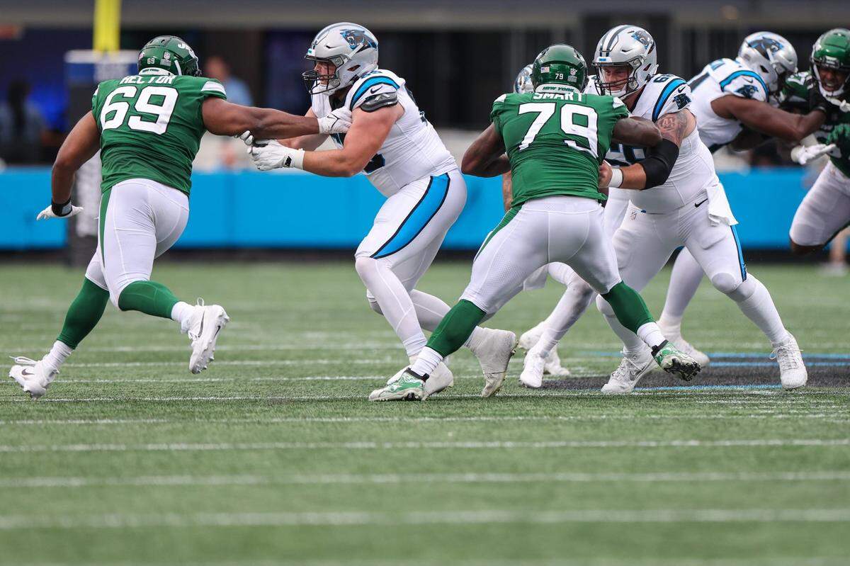 Panthers offensive linemen J. D. DiRenzo, second from left, and Sam Tecklenburg, right, fend off the Jets’ defense during the pre-season game at Bank of America Stadium on Saturday, August 12, 2023 in Charlotte, NC.
