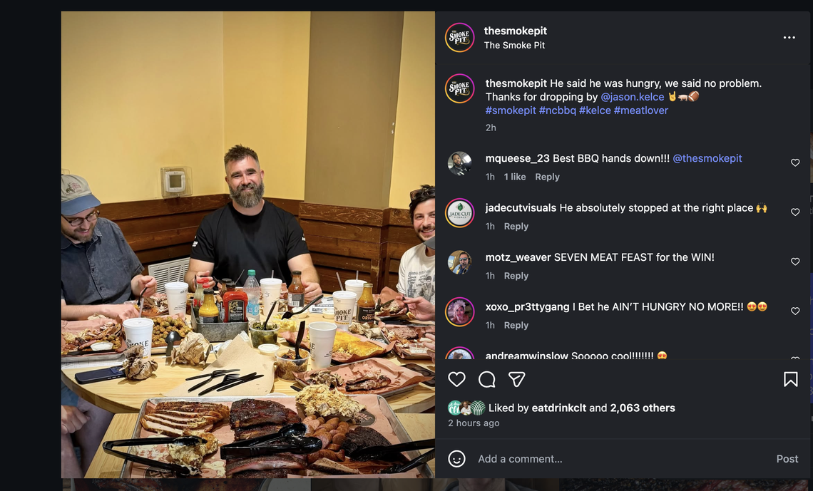 A screenshot of an Instagram post from “thesmokepit” featuring former NFL player Jason Kelce sitting at a large round table with two other men. The table is covered in massive trays of BBQ, including brisket, ribs, and sausage. The caption reads, “He said he was hungry, we said no problem. Thanks for dropping by @jason.kelce,” followed by several enthusiastic fan comments.