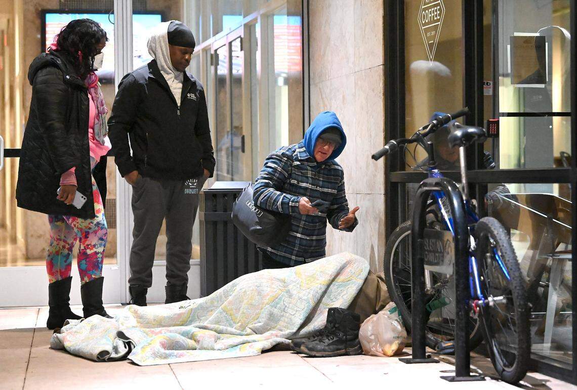Point-in-Time Count volunteers Jeanelle Perry, left, and Jerald Collins, center, listen while volunteer Joe Hamby, right, speaks with a person who is homeless along Church St. in uptown Charlotte, NC., on Thursday, January 26, 2023. Volunteers aim to get an accurate statistic of how many people in Charlotte are homeless, live in shelters or tents or cars, or otherwise have unstable housing arrangements.