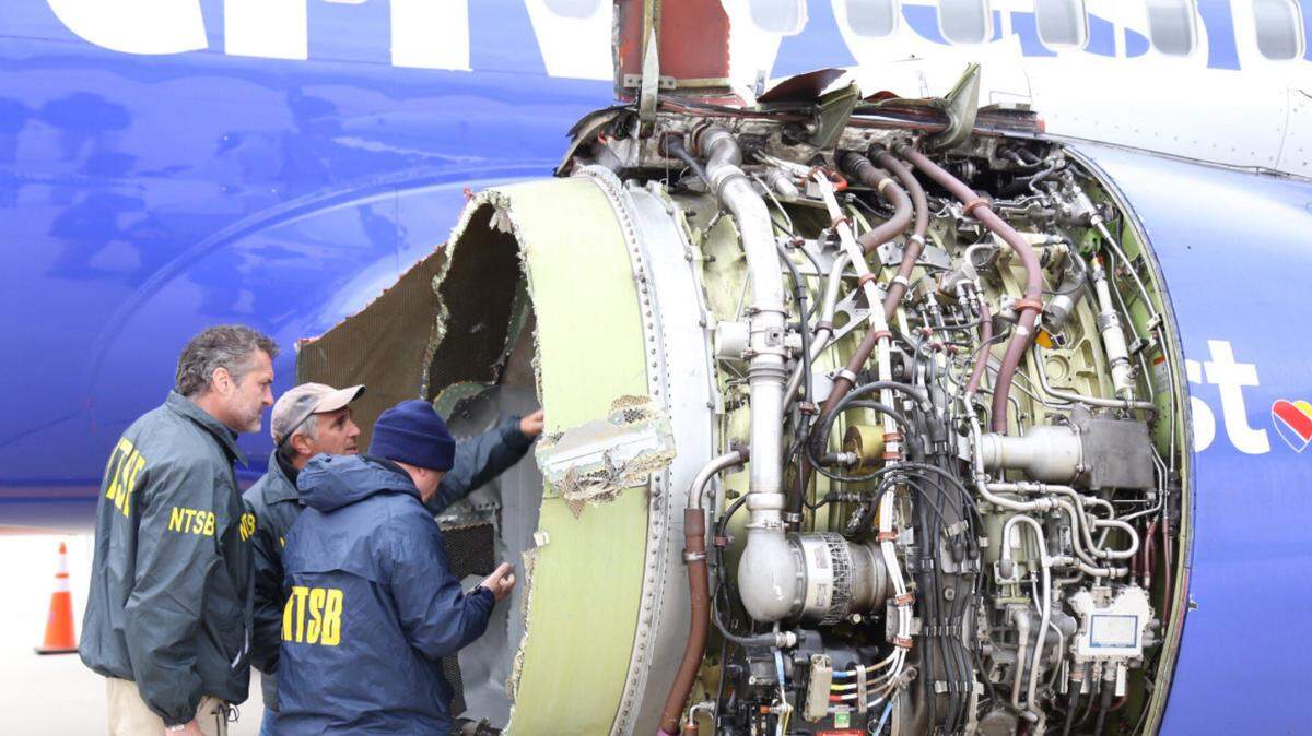 NTSB investigators examine damage to the engine of the Southwest Airlines plane that made an emergency landing in Philadelphia on Tuesday.