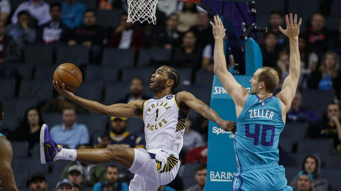 Indiana Pacers forward T.J. Warren, left, shoots a scoop shot as he drives past Charlotte Hornets forward Cody Zeller in the first half of an NBA basketball game in Charlotte, N.C., Monday, Jan. 6, 2020. (AP Photo/Nell Redmond)