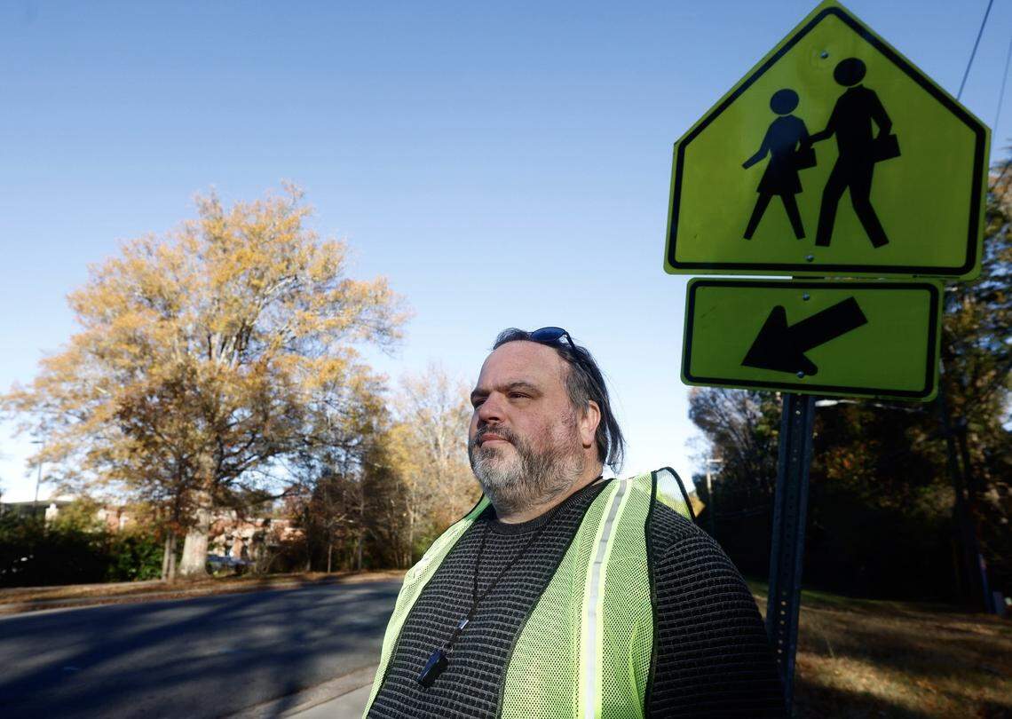 Adam McBroom, a parent of a child at Charlotte East Language Academy, watches the intersection leading to the school for Border Patrol and ICE agents during morning drop off