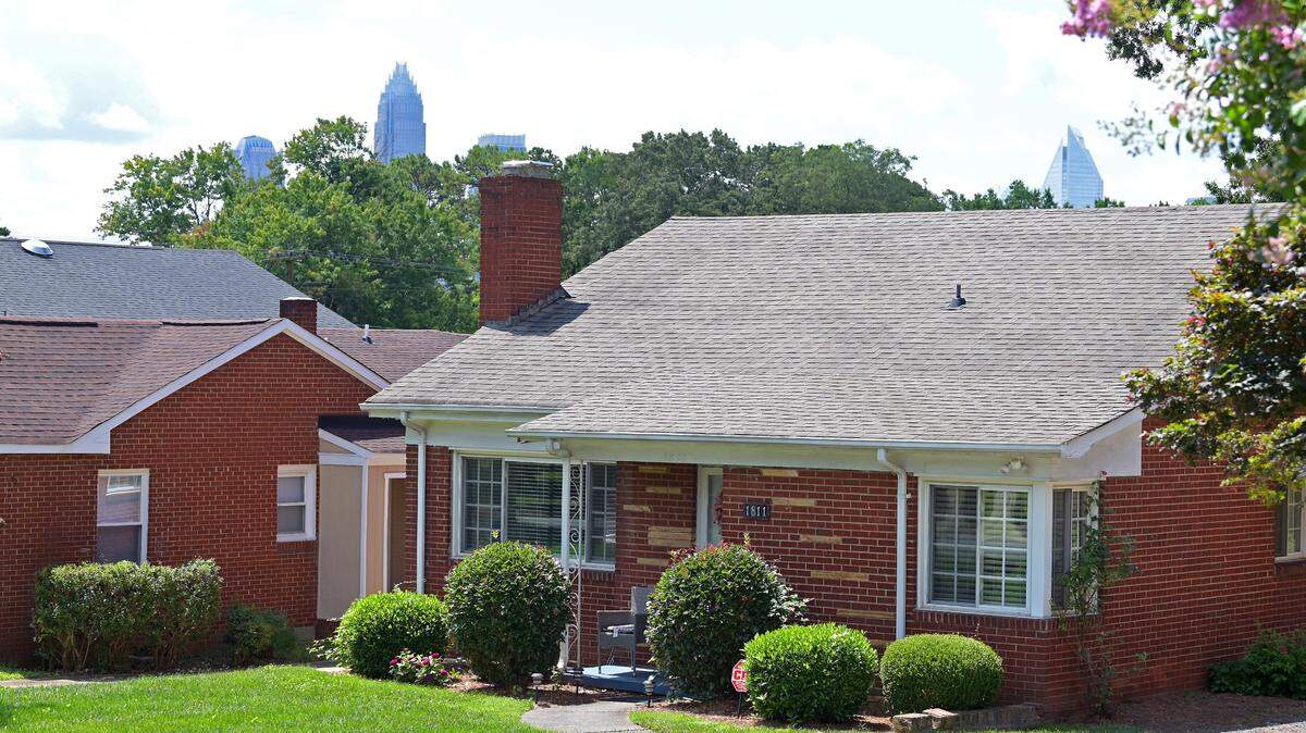 The Charlotte skyline peeks over the canopy behind homes along Patton Avenue in McCrorey Heights. The neighborhood could soon become a historic district, meaning it would join others like Fourth Ward and Plaza Midwood.