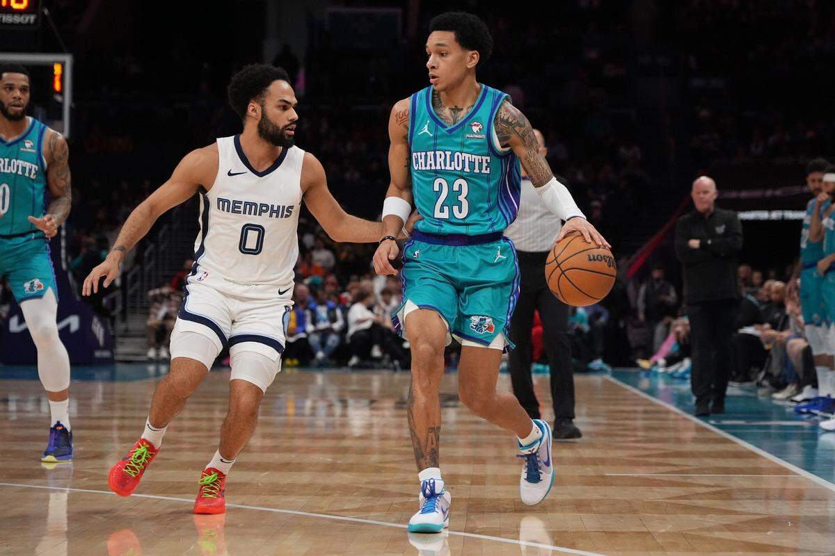 Feb 10, 2024; Charlotte, North Carolina, USA; Memphis Grizzlies guard Jacob Gilyard (0) defends against Charlotte Hornets guard Tre Mann (23) during the first quarter at Spectrum Center.