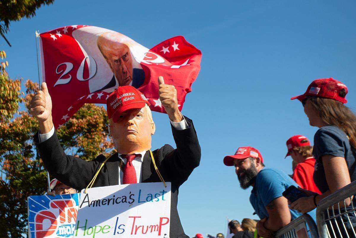 A person wearing a mask gives a thumbs up while greeting supporters of former President and Republican presidential candidate Donald Trump prior to a campaign rally at First Horizon Coliseum in Greensboro, N.C. on Saturday, Nov. 2, 2024.