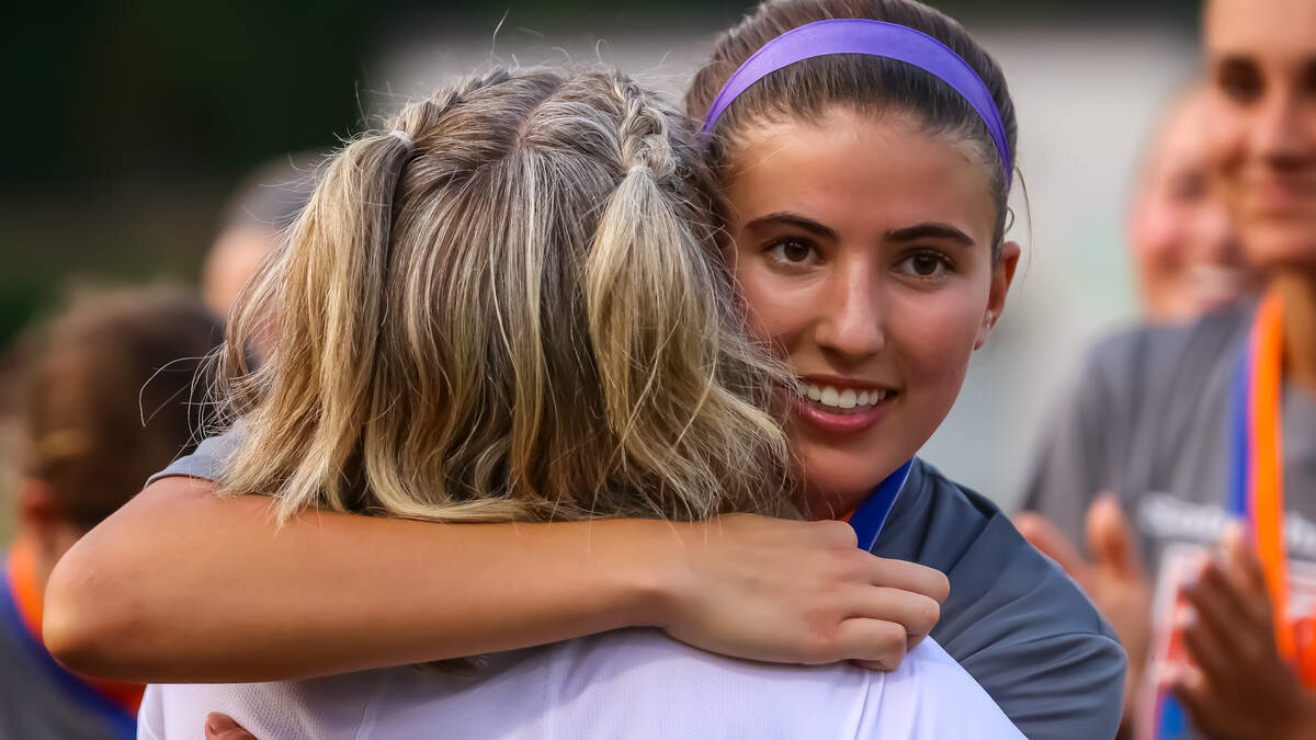 Ardrey Kell’s Ellie Riechman hugs her coach, Kim Montgomery, after receiving MVP at the NCHSAA 4A state championship game in Matthews NC at the Sportsplex on May 31. 2025