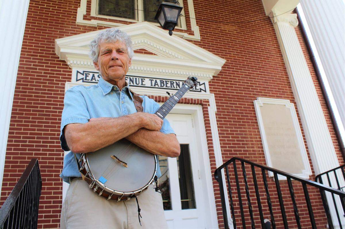 Banjo player Harry Taylor stands in front of East Venue Tabernacle Church.