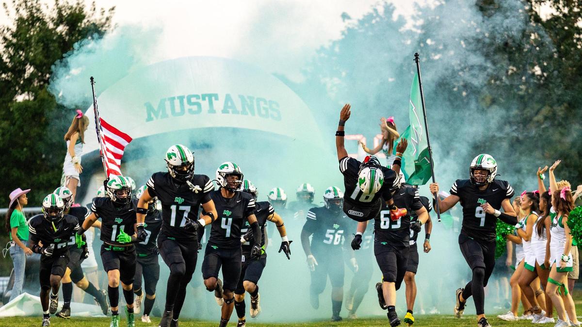 Myers Park Elijah Barber does a backflip as the team takes to the field against Ardrey Kell in Charlotte at Myers Park High on Friday, October 6, 2023.