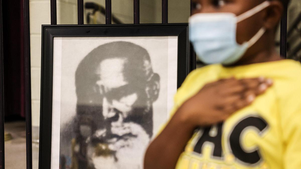 Ky’shon Cash-Glover holds his hand over his heart during the Pledge of Allegiance in front of a portrait of Charles H. Parker during the renaming ceremony for Charles H. Parker Academic Center in Charlotte, on Wednesday, October 6, 2021.