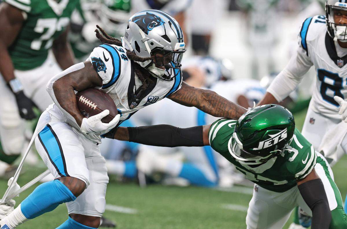 Carolina Panthers running back Mike Boone, left, pushes New York Jets cornerback Qwan’tez Stiggers, right, aside on a run to the outside during first quarter action at Bank of America Stadium in Charlotte, NC on Saturday, August 17, 2024.