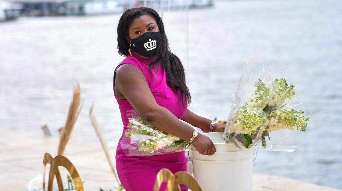 LaToya Evans helped the wedding planner arrange the decorations for the ceremony before the rain came in.