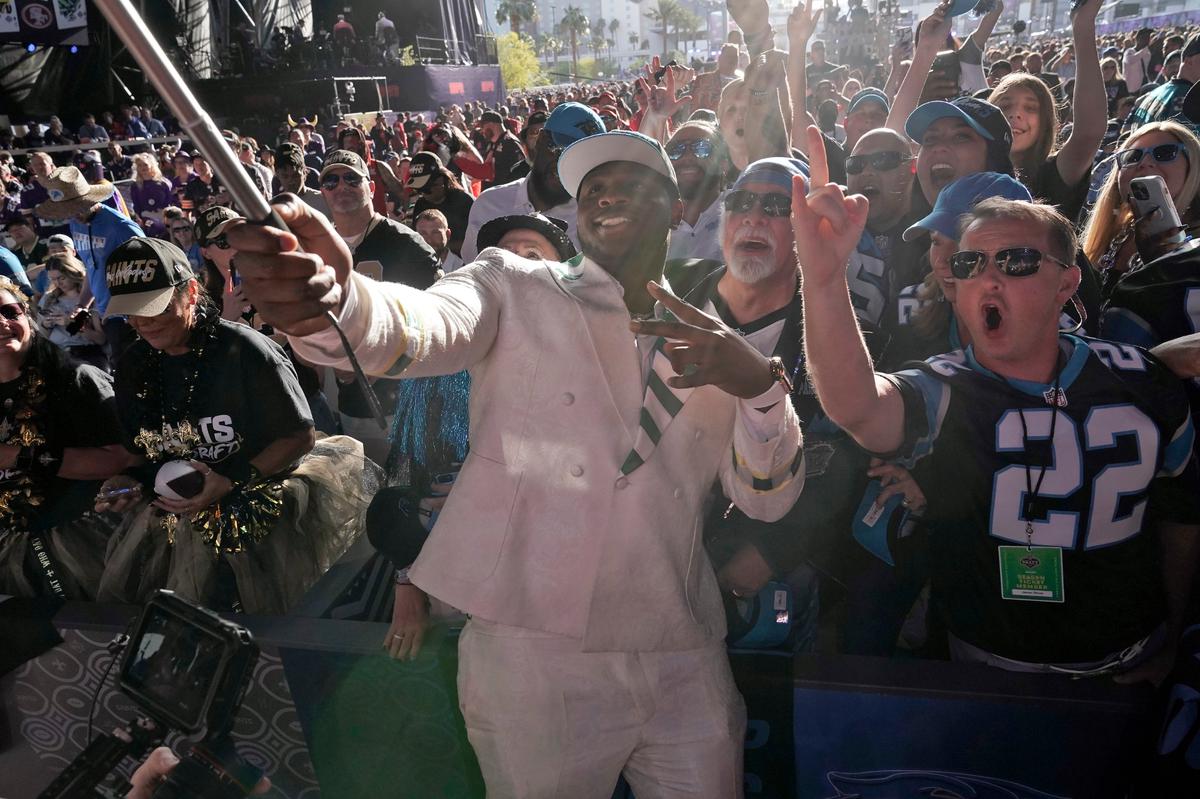 North Carolina State offensive tackle Ikem Ekwonu takes selfies with fans after being picked by the Carolina Panthers with the sixth pick of the NFL football draft Thursday, April 28, 2022, in Las Vegas. (AP Photo/John Locher)