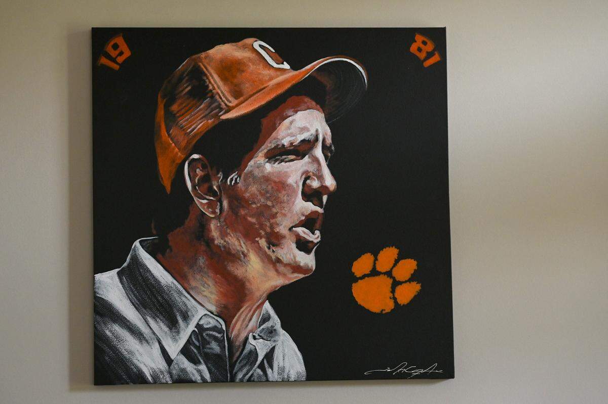 Former Clemson Tigers head football coach Danny Ford’s likeness is reflected in a painting in his home office on Friday, July 22, 2022. Ford led the Tigers to a 12-0 season in 1981. Ford won ACC Coach of the Year in 1981 and was inducted into the College Football Hall of Fame in 2017.