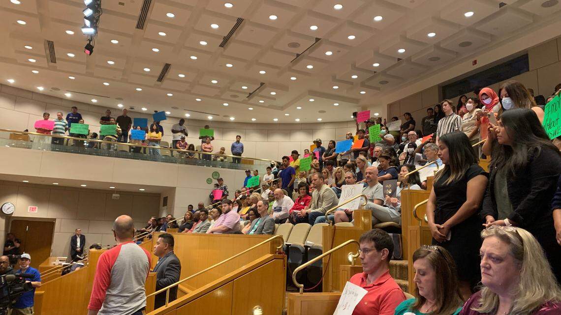 Vendors from the Central Flea Market hold signs for Charlotte City Council at a meeting Monday, July 11, 2022.