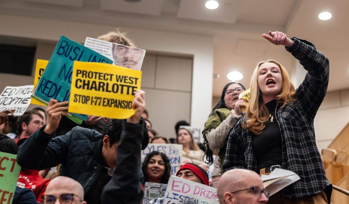 Residents concerned about the I-77 project chant and hold up signs during the City Council meeting at the Charlotte-Mecklenburg Government Center in Charlotte, N.C., on Monday, February 23, 2026.